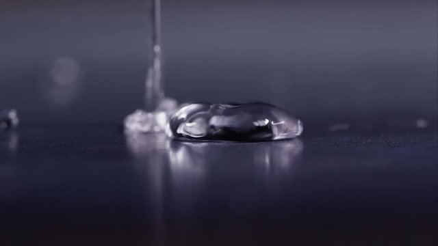 Water droplets bouncing on shinny surface.