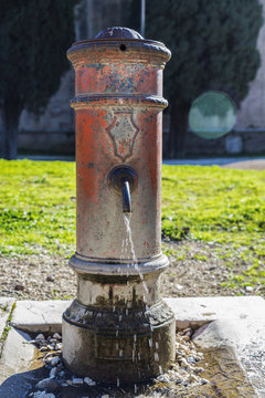 Old metal fountain with open faucet