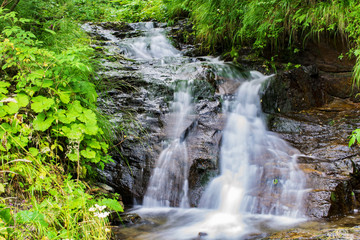 Waterfall on mountain river in Carpathian Mountains , Romania