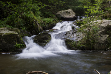 Obraz premium Waterfall on mountain river in Carpathian Mountains , Romania
