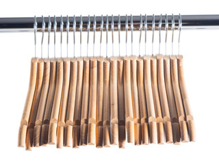 Wooden hanger on metal rail over white isolated background