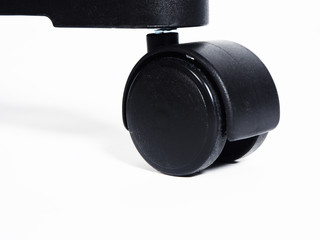 Black plastic furniture wheel over white background