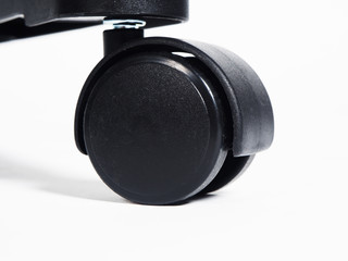 Black plastic furniture wheel over white background