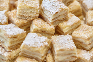 Stack of square bakery slices desserts or cakes on plate