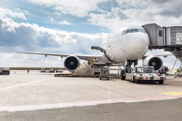 Fototapeten Das weiße Unkenntlich-Flugzeug am Flughafen befördert Passagiere über eine Teleskopleiter © EdNurg