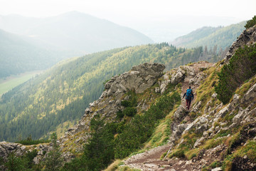 Fototapeta na wymiar Hiker trekking aone along a rock mountain path