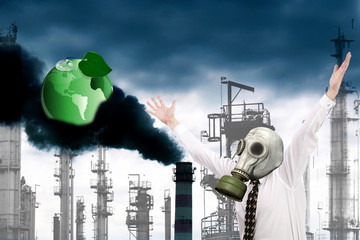 A frightened engineer ecologist in a gas mask against the background of smoking industrial pipes throwing out toxic gases into the atmosphere