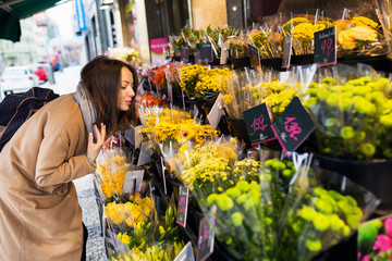 Woman customer at flower shop smelling the aroma and choosing the bouquet