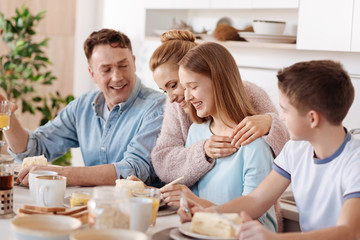 Joyful friendly family having breakfast together