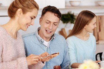 Positive couple having breakfast with their daughter