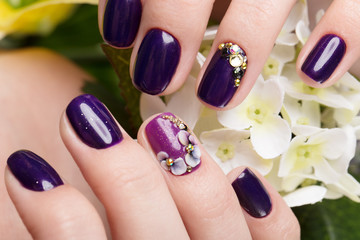 Shot beautiful manicure with flowers on female fingers. Nails design. Close-up. Picture taken in...