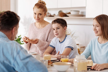 Positive children having breakfast with their parents