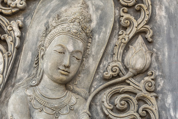 Black and white picture of Buddha statue. Buddha's face on wall