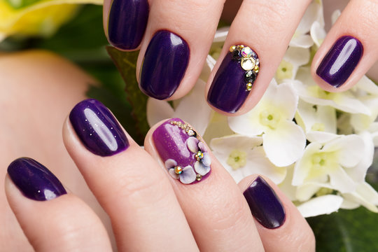 Shot beautiful manicure with flowers on female fingers. Nails design. Close-up. Picture taken in the studio on a white background.