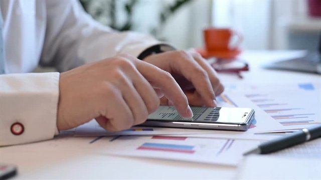 Businessman Using Mobile Phone With Growth Graph Chart And Stacks Data,