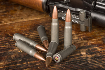 Rifle cartridges caliber 7.62 x 39 mm Kalashnikov mashine gun on wooden background. 