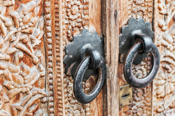 Old handles on the door with carved patterns and ornaments