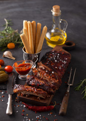 Delicious barbecued ribs seasoned with a spicy basting sauce and served with chopped fresh...