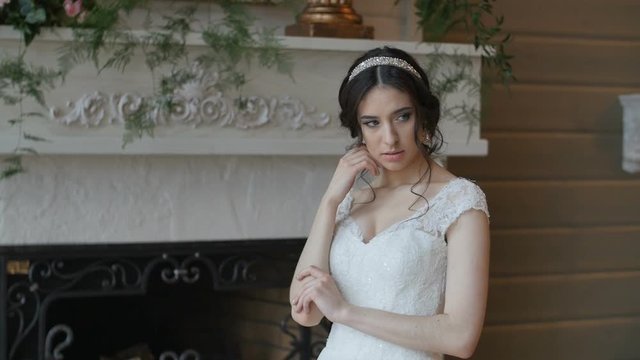Bride in white dress staying indoors and pose for photographer
