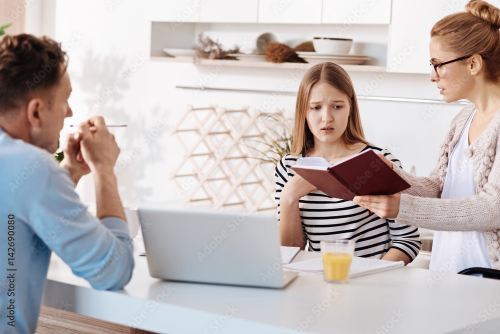 Wall mural Strict parents scolding their daughter for bad marks at school