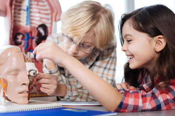 Engaging positive kids examining human body model