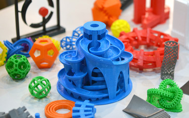 Models printed by 3d printer. Bright colorful objects printed on a 3d printer on a table