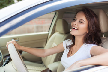 Fototapeta na wymiar Young Happy Smiling Woman Driving Car
