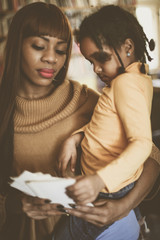 Mother and daughter reading together in library.