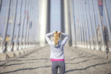 Morning exercise along the river. A young woman on recreation and jogging