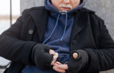 Old bearded male person collecting coins