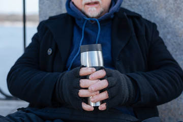 Close up of thermo cup being in male hands