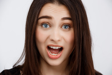 Close up portrait of beautiful surprised brunette girl looking in camera