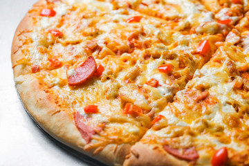 pizza with sausage, by cut to pieces on a metal table. selective focus on the filling close-up.
