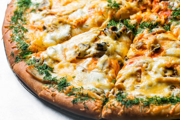 pizza with mushrooms and vegetables, by cut to pieces on a metal table. selective focus on the filling close-up.