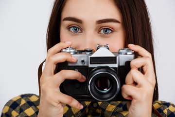 Close up portrait of young beautiful brunette photographer over white background.