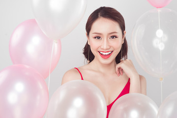 Asian fashion woman smiling and looking at camera with balloons background.