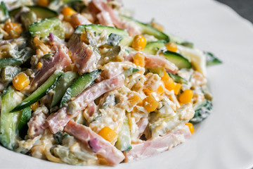 salad with ham on white plate. selective focus