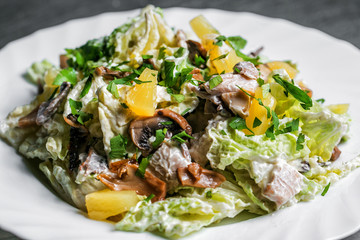 salad with mushrooms and oranges on white plate. selective focus