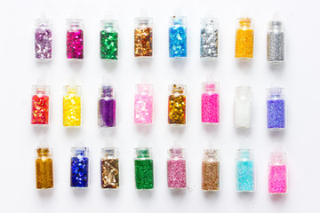 Colorful glitters for nail art and makeup in small glass jars