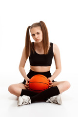 Young pretty girl posing with basketball over white background.