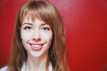 Woman smiling on red background