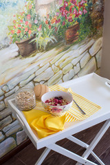 healthy breakfast with natural yogurt, muesli and berries in plate in flower on white tray