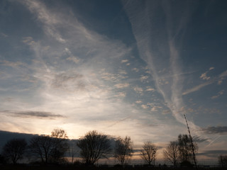 Sunset Silhouette over Fields with Houses in Distance