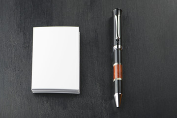 Business card and pen on black background. Horizontal shoot.