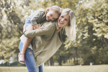  Little girl lying on mother's piggyback .