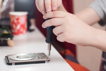 Hands of a little boy with the screwdriver,