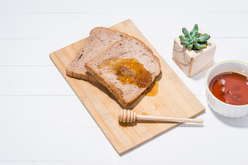 Close-up of slice of toast bread with honey on wood table