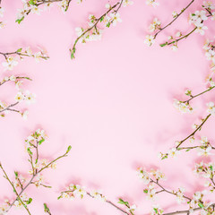 Fototapeta na wymiar Frame of spring flowers on pink background. Flat lay, top view. Spring time background.
