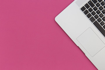 Laptop computer on bright pink background