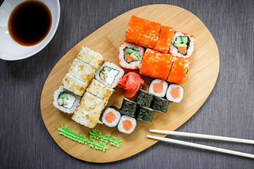 Sushi rolls, sauce and chopsticks on a grey background. Top view. Flat lay. Restaurant food.